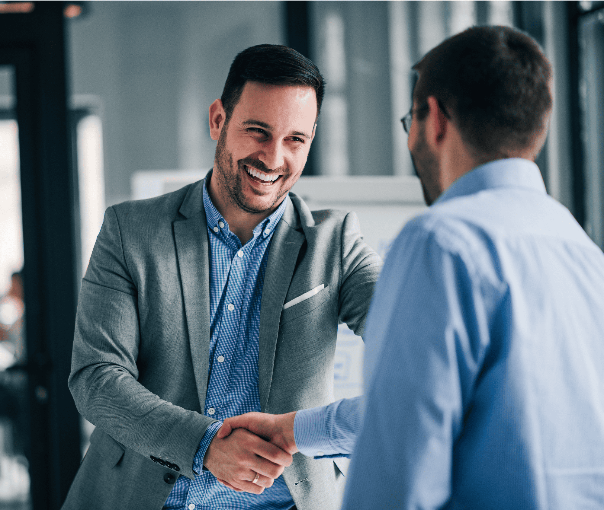 Business professionals shaking hands in a corporate office.